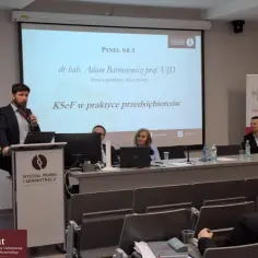 Panel dyskusyjny z udziałem prelegentów i publiczności, z prezentacją na ekranie.