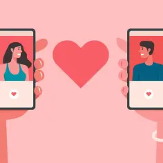 Dwie dłonie trzymają telefony z profilami osób. Między nimi serce. To może być odpowiedź na pytanie: grindr co to?