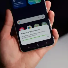 Telefon w dłoni pokazuje komunikat o aktualizacji oprogramowania Android. Proces przygotowania do ponownego uruchomienia trwa, osiągając 90%.