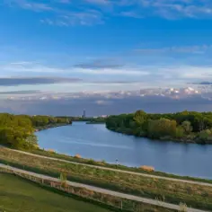Malowniczy widok na rzekę, nad którą leży Kraków. W oddali widać zarys miasta.