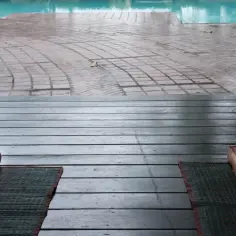 Drewniany taras z poduszkami i matami, idealne miejsce na relaks co pod basen ogrodowy.
