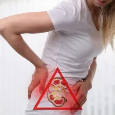 Kobieta z bólem w boku, wskazującym na kolkę nerkową. W tle widoczny przekrój nerki.