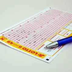 Kupon LOTTO 6aus49 z zaznaczonymi liczbami i długopisem. Czy to klucz do odpowiedzi, ile zarabia pracownik Lotto?