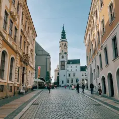 Ulica w mieście Wałbrzych z wieżą ratuszową i brukowanym rynkiem.