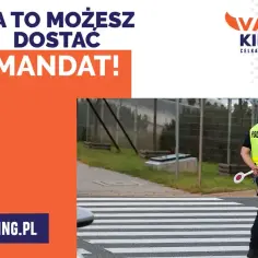 Policjant stoi na pasach, gotowy do interwencji. Uważaj na przejściu dla pieszych, by nie dostać mandatu!