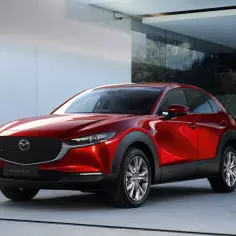 Czerwona Mazda CX-30 lśni w nowoczesnym otoczeniu, gotowa na miejskie przygody.