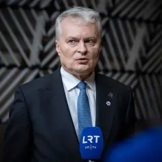 Prezydent Litwy w garniturze i krawacie udziela wywiadu przed mikrofonem LRT TV.