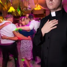 Ksiądz z ręką na sercu obserwuje tańczących ludzi. Czy w wielkim poście można tańczyć?
