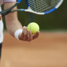 Gracz trzyma piłkę tenisową, gotowy do serwisu. To może być decydujący punkt, prawdziwy super tie break!