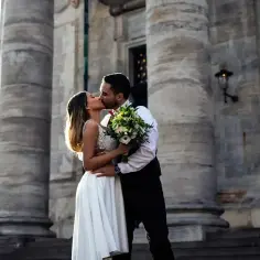 Para w dniu ślubu całuje się na tle monumentalnej budowli. Czy wiek mężczyzny ma znaczenie, by wziąć ślub?