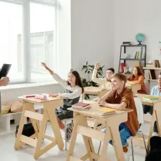 Nauczyciel pyta, ile trzeba mieć frekwencji, żeby zdać. Uczniowie z podniesionymi rękami czekają na odpowiedź.