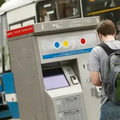 Chłopak z plecakiem kupuje mpk wrocław bilety ulgowe w automacie.