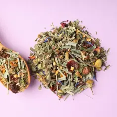 Mieszanka suszonych ziół i kwiatów na łyżce i obok. Dowiedz się, jak suszyć świeże zioła w piekarniku bez utraty koloru i aromatu.