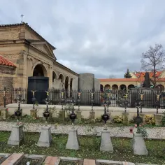 Wyszehrad: cmentarz z rzędami krzyży i arkadowymi budynkami.