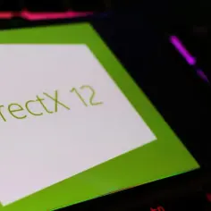 Zielony ekran z napisem DirectX 12 na tle podświetlanej klawiatury.