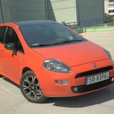 Pomarańczowy Fiat Punto z czarnym dachem. Zastanawiasz się, ile pali fiat punto 1.4 benzyna? Ten model może być odpowiedzią.