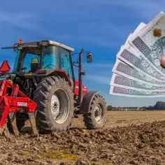 Czerwony traktor na polu, a obok ręka trzymająca banknoty. Czy to zapowiedź wysokiego podatku rolnego?