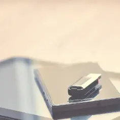 Pendrive leży na smartfonie, gotowy do podłączenia. Dowiedz się, jak podłączyć pendrive do telefonu, by przenieść dane.