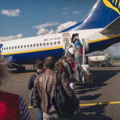Pasażerowie wsiadają po schodkach do samolotu Ryanair.