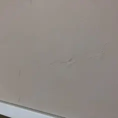 Purchle na ścianie od wilgoci, tworzące faliste wzory.