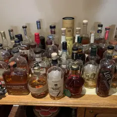 Kolekcja butelek bourbonu, idealna do nauki, jak pić bourbon. Różne marki i rozmiary, gotowe do degustacji.