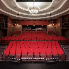 Puste czerwone fotele w teatrze czekają na widzów. Wnętrze z żyrandolem i dyskotekowymi kulami zapowiada bogaty repertuar teatru Rampa.