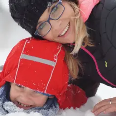 Uśmiechnięta mama i dziecko w śniegu. Trójmiasto atrakcje dla dzieci zimą to świetna zabawa na świeżym powietrzu.