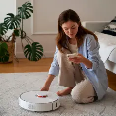 Kobieta sprawdza telefon, bo robot sprzątający nie wraca do bazy. Jak to naprawić samemu?