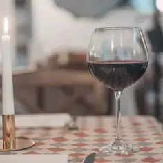 Romantyczny wieczór przy świecy i kieliszku czerwonego wina. Czy można pić wino po terminie przydatności na etykiecie? To pytanie pozostaje otwarte.