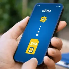 Dłoń trzyma smartfon z ekranem pokazującym proces aktywacji eSIM. Widoczny symbol tradycyjnej karty SIM przechodzi w cyfrową wersję.