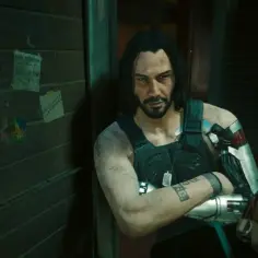 Johnny Silverhand, grany przez aktora Keanu Reevesa, z cybernetycznym ramieniem i tatuażem na przedramieniu, stoi obok żółtej budki telefonicznej.