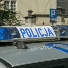 Niebieskie światła policyjne i napis "POLICJA" na dachu radiowozu. Uważaj na przegląd, bo czeka mandat za brak przeglądu.