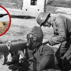 Żołnierz w masce gazowej przygotowuje panzerfaust, podczas gdy drugi żołnierz pochyla się nad nim. W okręgu widać nowoczesny żołnierz celujący z podobnej broni.