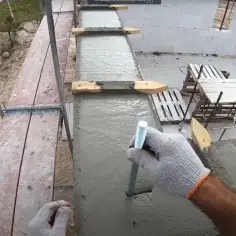 Rękawica w ręku trzyma pręt, który zaraz zostanie użyty do tego, jak zamontować kotwę do betonu.