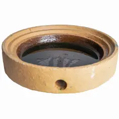 Ceramic element z otworem, wypełniony ciemną cieczą, ilustruje jak odprowadzić skropliny z komina systemowego.