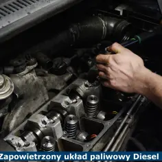 Mechanik pracuje nad silnikiem Diesla, próbując rozwiązać problem zapowietrzony układ paliwowy. Widoczne elementy silnika i narzędzia.