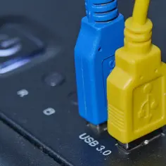 Niebieski i żółty kabel USB 3.0 podłączone do urządzenia. Kolory USB mogą oznaczać różne standardy lub funkcje.