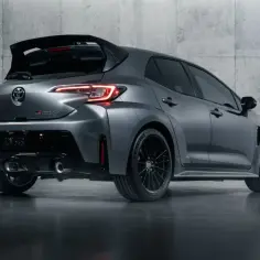 Szary Toyota Corolla GR z agresywnym spojlerem i podwójnymi końcówkami wydechu, gotowy do akcji.