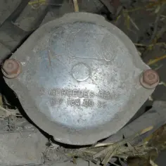 Metalowa osłona z napisem MERCEDES-BENZ 617 184 00 25. Może to być część poszukiwanego kodu silnika Mercedes W204.