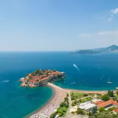 Wyspa Sveti Stefan w Czarnogórze, z malowniczą plażą i turkusowym morzem. Sprawdź czarnogóra ceny, by zaplanować wakacje!