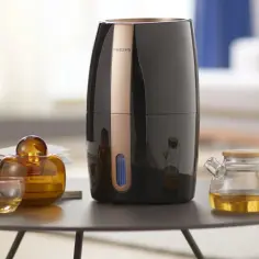 Elegancki oczyszczacz powietrza Philips i szklane naczynia z płynem. Czy do oczyszczacza powietrza można wlać olejek?