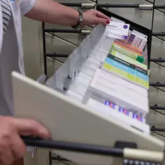 Farmaceutka sięga po opakowanie ellaOne. Warto wiedzieć, ile kosztuje tabletka dzień po, by móc szybko zareagować.