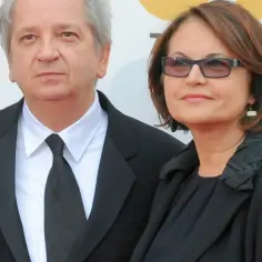 Juliusz Machulski z żoną, w eleganckich strojach, pozują do zdjęcia.