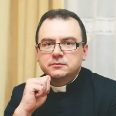Duchowny w okularach zamyślony, zastanawia się, czy po przeklinaniu można iść do komunii.