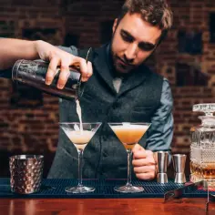 Barman przelewa drinka do kieliszka. Dowiedz się, jak schłodzić kieliszek do martini w 30 sekund bez lodu.