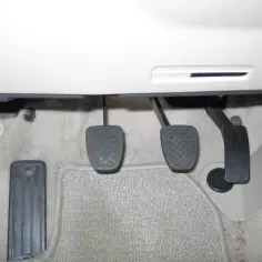 Wymiana pompy sprzęgła Volvo V50: widok na pedały sprzęgła, hamulca i gazu.
