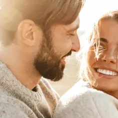 Uśmiechnięta para, symbol monogamii, cieszy się ciepłem słońca.