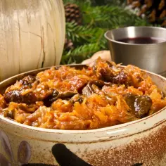 Tradycyjny bigos z różnymi rodzajami mięsa, podany w glinianym naczyniu. Idealne danie na zimę, które mięso do bigosu najlepiej podkreśli.