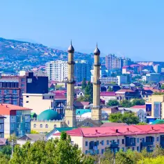 Miasto na nizina nadkaspijska z meczetem i minaretami, otoczone wzgórzami.