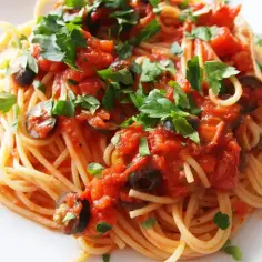 Pyszne spaghetti z sosem pomidorowym, oliwkami i natką pietruszki. Idealny przepis, jak zrobić spaghetti na obiad.